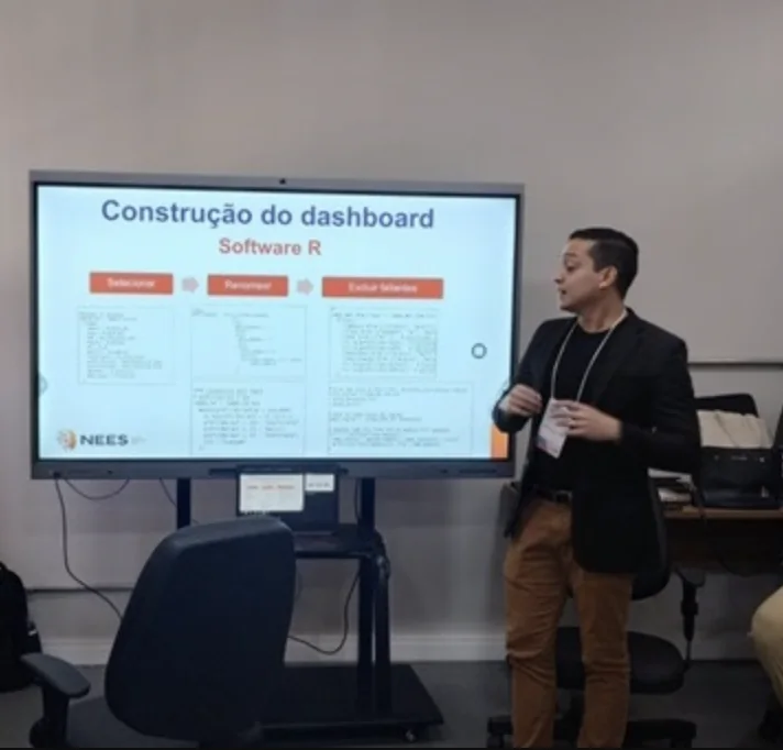 Julio Cezar apresentando, ao lado de uma tela com o título Construção do dashboard