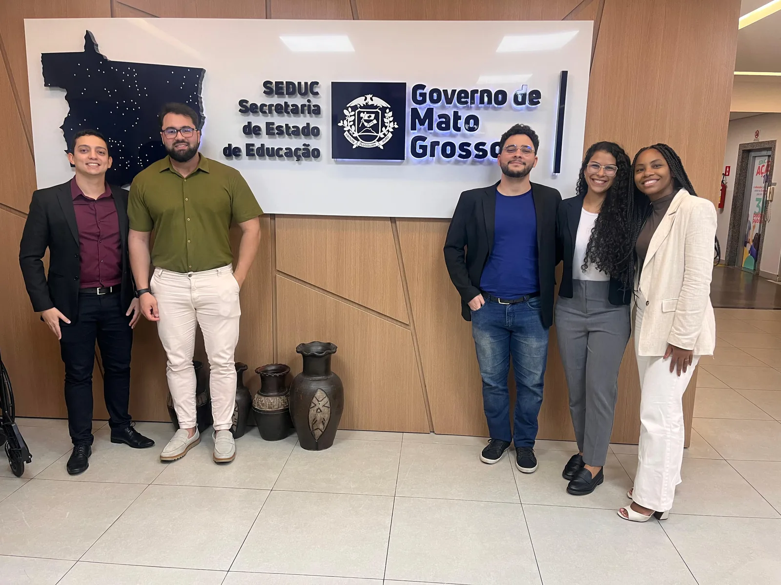 Julio Cezar com quatro colegas diante do letreiro da Secretaria de Estado de Educação de Mato Grosso